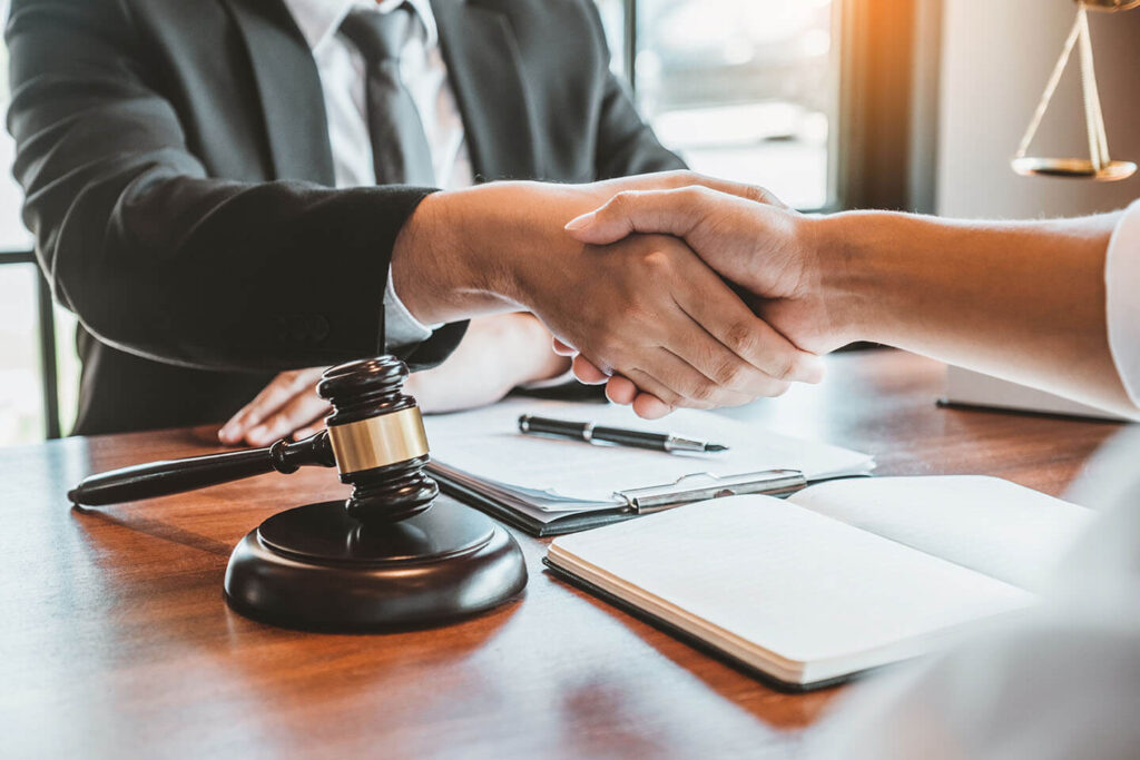 a lawyer shaking the hand of a client he helped with a business law case in Highland Illinois.